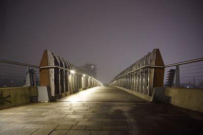 Illuminated bridge against clear sky at night