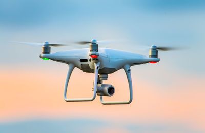 Low angle view of drone flying against sky