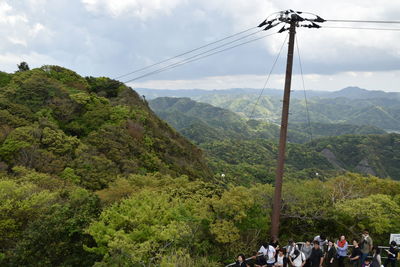 Group of people on mountain against sky