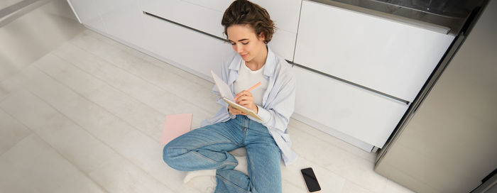 Portrait of young woman standing on floor