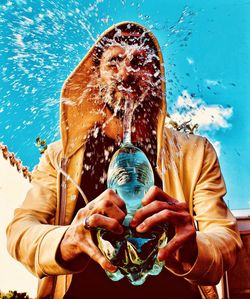 Digital composite image of man holding blue water
