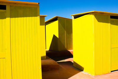 Sunlight falling on yellow wall against clear sky