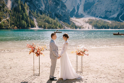 Rear view of woman with umbrella on shore