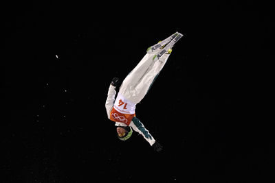 Person paragliding against black background