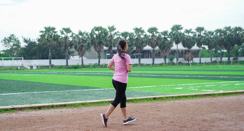 Full length of woman playing soccer on field