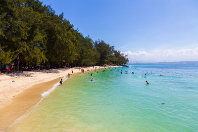 People on beach against blue sky