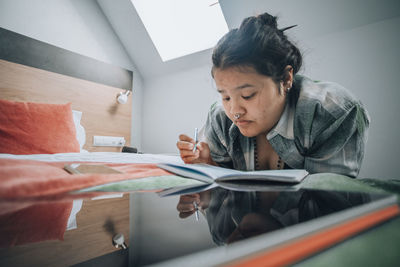 Typical study moment, student uses both her tablet and notebook, set in well organized study space