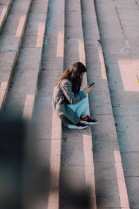 High angle view of girl sitting on staircase