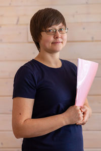 Business woman in glasses holding files and pen in her hands