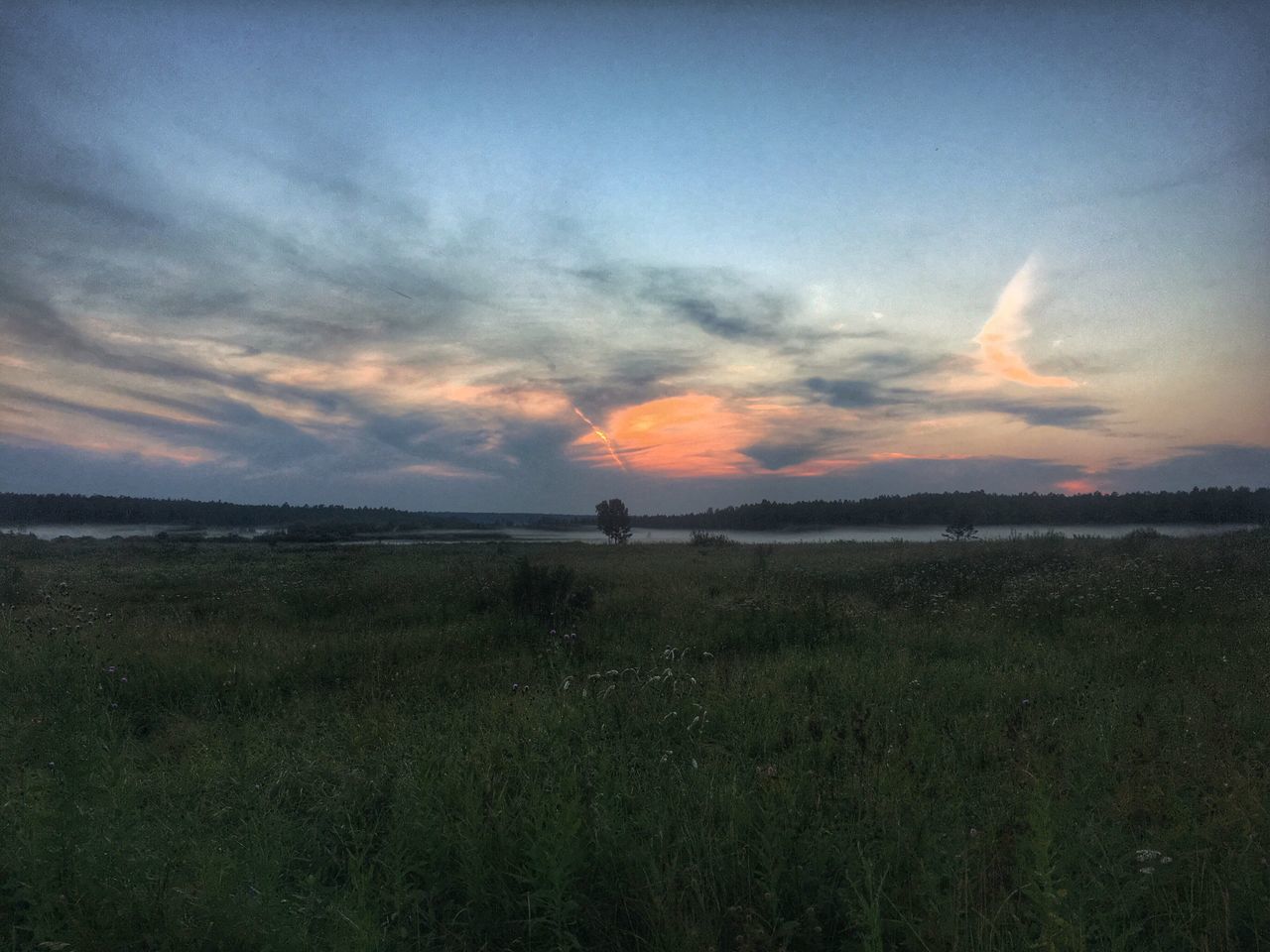 tranquil scene, sunset, scenics, tranquility, beauty in nature, grass, dusk, landscape, sky, water, nature, field, cloud - sky, remote, non-urban scene, orange color, mountain, vacations, sea, dramatic sky, blue, shore, grassy, cloudy, storm cloud, tourism