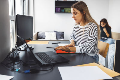 Young woman using laptop at office