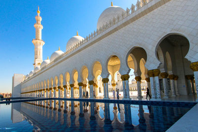 The sheikh zayed grand mosque abu dhabi with pool on its side 