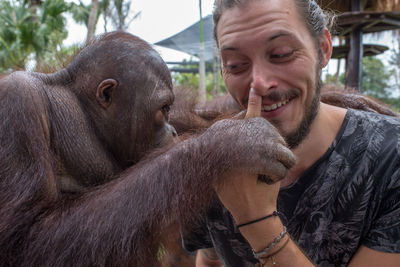 A men bonding with an orangutan