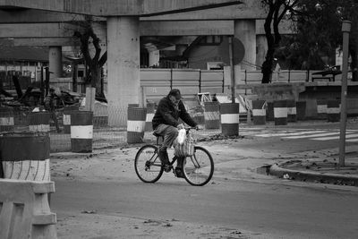 Rear view of man riding bicycle on street