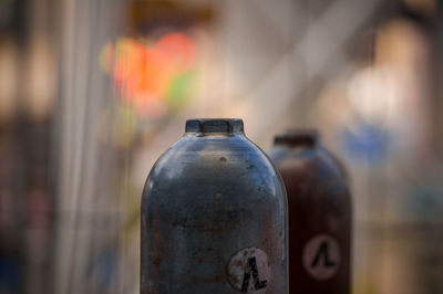 Close-up of gas cylinders against blurred background