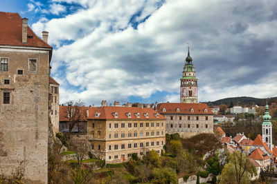 Buildings in town against cloudy sky