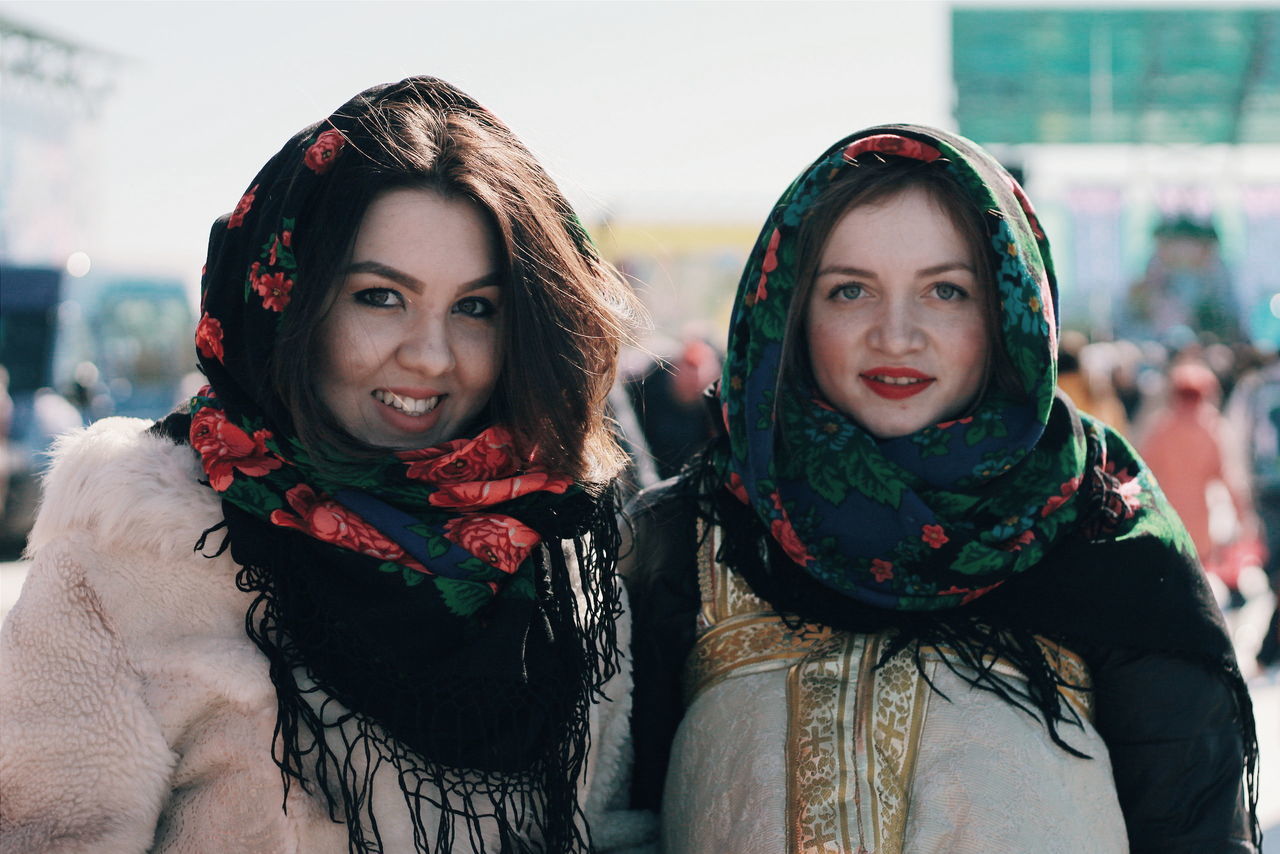 lifestyles, togetherness, looking at camera, portrait, smiling, leisure activity, bonding, person, happiness, front view, love, casual clothing, young adult, toothy smile, young women, focus on foreground, warm clothing, friendship