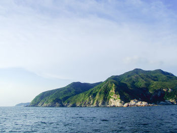 Scenic view of sea and mountains against sky