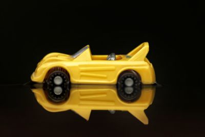 Close-up of yellow toy car against black background