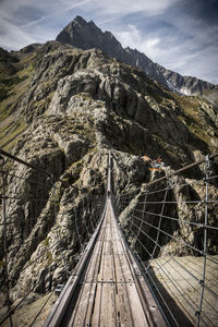 View of footbridge on mountain against sky