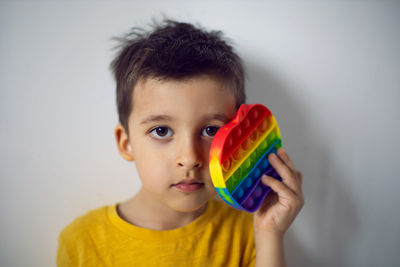 Boy in a yellow t-shirt plays a fashion game pop it in the form of a silicone apple