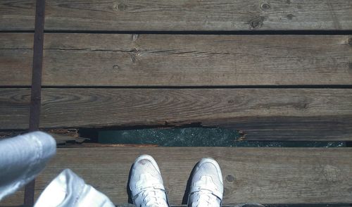 Low section of person standing on hardwood floor