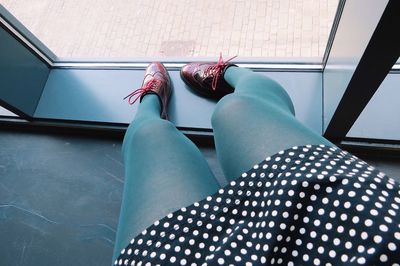Low section of young woman with stockings on window sill