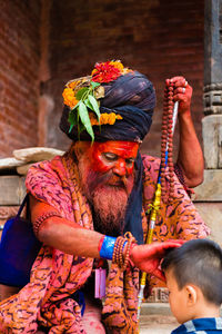 Portrait of man with multi colored bell outdoors