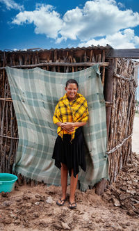 Full length portrait of smiling woman standing outdoors