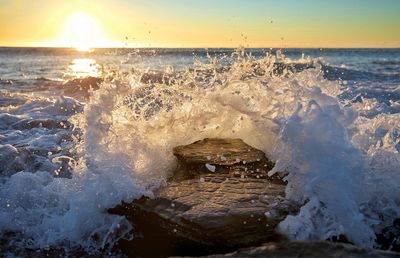 Waves splashing on shore during sunset