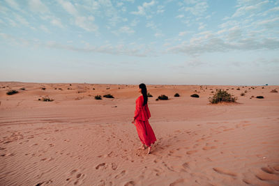 Rear view of woman walking on desert