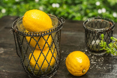 High angle view of lemons in container on wooden table
