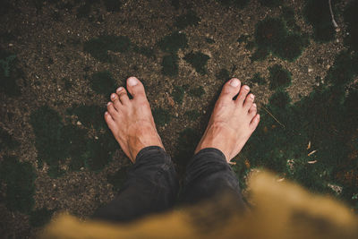 Low section of man standing on land