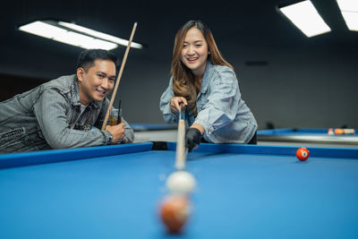 Midsection of woman playing pool