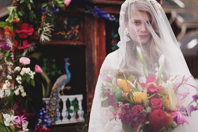 Portrait of beautiful bride wearing wedding dress with bouquet