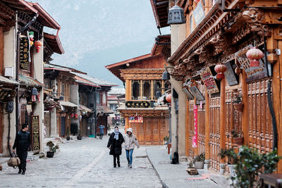 People walking on street amidst buildings in city