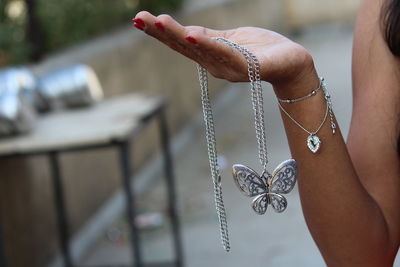 Cropped hand holding necklace