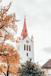 Low angle view of trees and building against sky