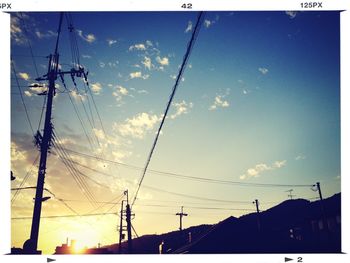 Low angle view of electricity pylon against sky