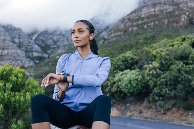 Portrait of young woman sitting on rock