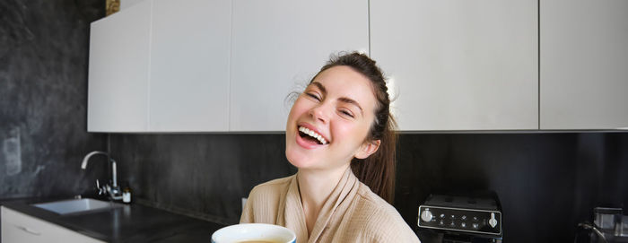 Portrait of young woman sitting at home