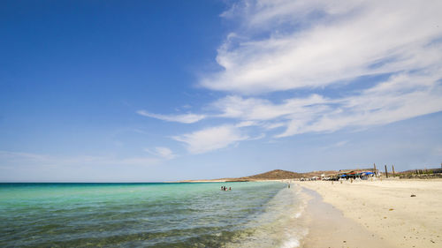 View of calm beach against blue sky