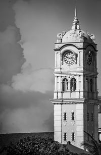 Low angle view of clock tower by building against sky