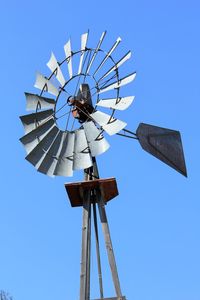 Low angle view of american-style windmill against clear blue sky