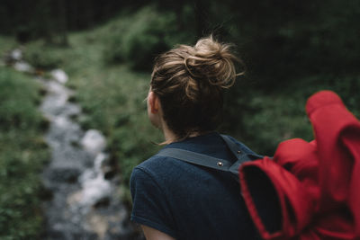 Rear view of hiker carrying backpack at forest