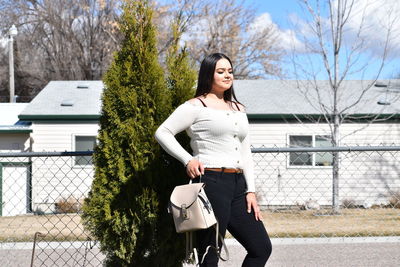 Full length of woman standing by tree against plants