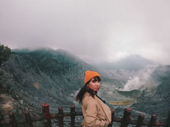 Portrait of woman standing against mountain