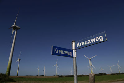 Sign boards at windmill against clear sky