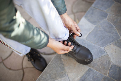 Low section of woman tying shoelace