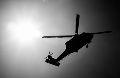 Low angle view of silhouette airplane against sky